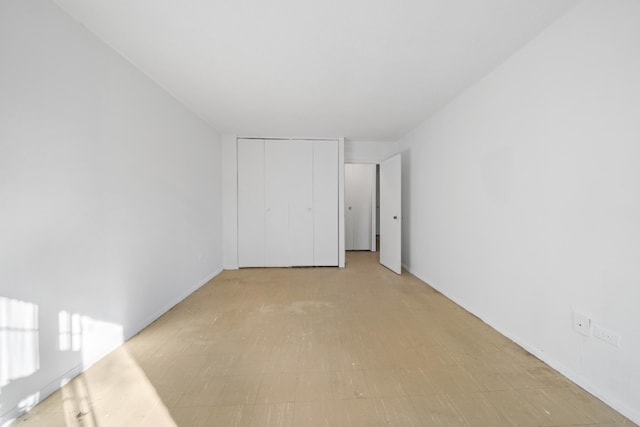 unfurnished bedroom featuring light floors and a closet