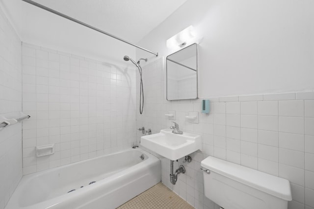 full bath featuring shower / tub combination, toilet, a sink, tile walls, and tile patterned floors