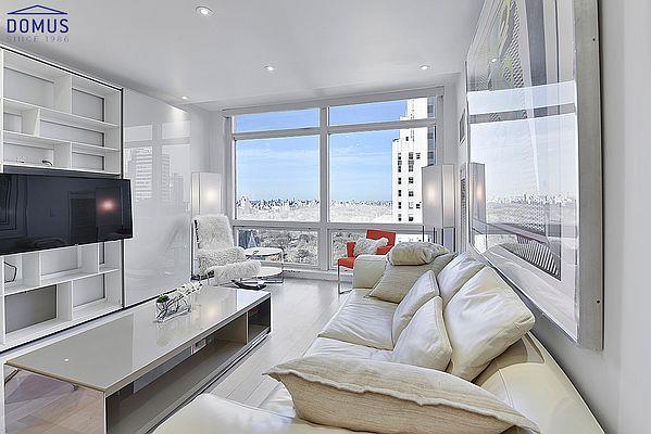 living room with hardwood / wood-style flooring, a healthy amount of sunlight, and a wall of windows