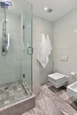 bathroom featuring a bidet, tile walls, and walk in shower