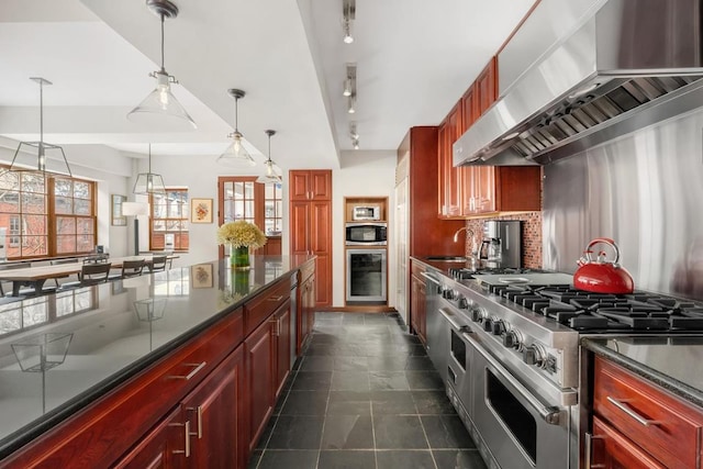 kitchen with reddish brown cabinets, dark countertops, double oven range, pendant lighting, and exhaust hood