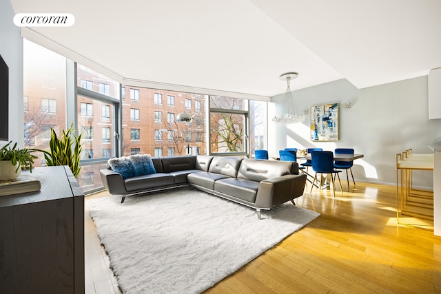 living room featuring a wall of windows, visible vents, baseboards, and wood finished floors