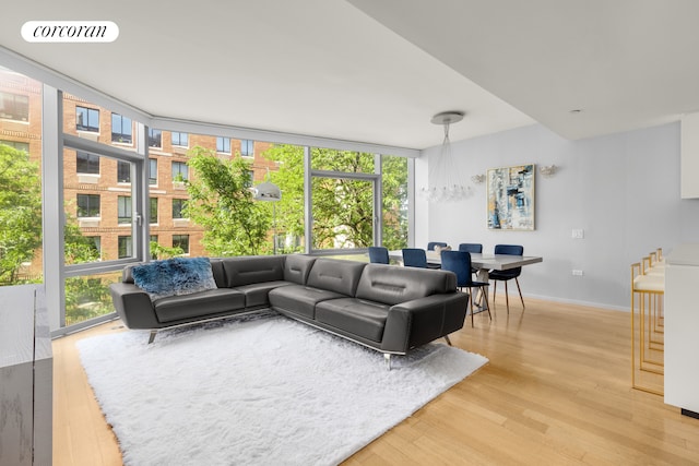 425 W 53rd St Unit 409, New York City, NY 10019 - living area with floor to ceiling windows, light wood-style flooring, and baseboards