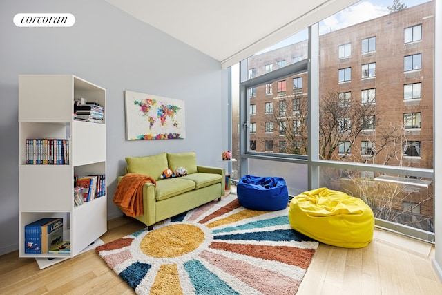 sitting room with visible vents, wood finished floors, and high vaulted ceiling
