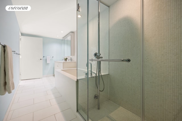 bathroom with walk in shower, vanity, and tile patterned flooring