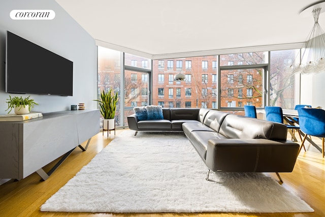 living area featuring a view of city, floor to ceiling windows, wood finished floors, and visible vents