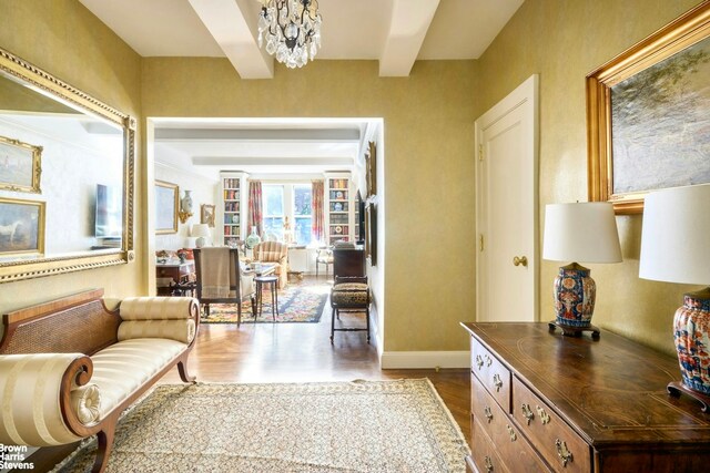 interior space with hardwood / wood-style flooring, beam ceiling, and a chandelier