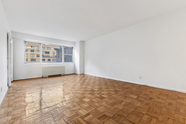 empty room with radiator and baseboards