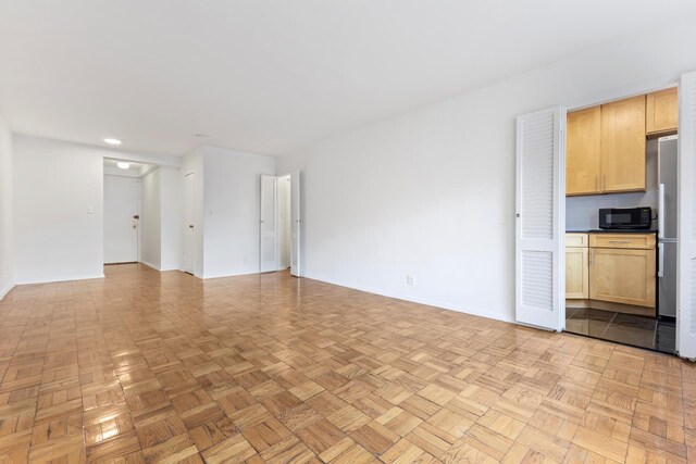 unfurnished living room with baseboards