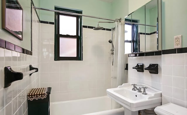 full bathroom with sink, backsplash, tile walls, toilet, and shower / tub combo with curtain