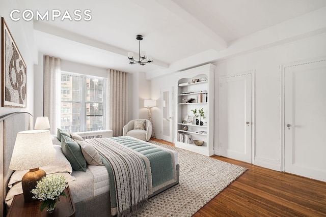 bedroom with hardwood / wood-style floors, an inviting chandelier, and beamed ceiling