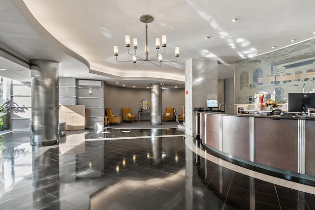 reception area featuring decorative columns and an inviting chandelier