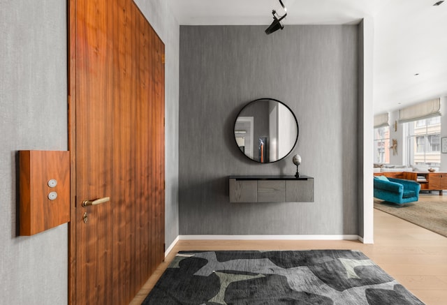 hallway with light wood finished floors and baseboards