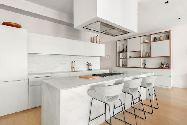 kitchen featuring white fridge, a center island, white cabinets, light hardwood / wood-style flooring, and sink