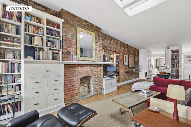 living room with brick wall, a brick fireplace, and light wood-type flooring