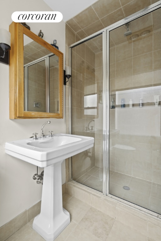 bathroom with a shower with shower door and tile patterned flooring