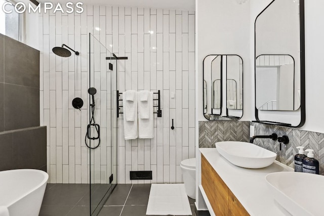 bathroom with vanity, toilet, tile patterned floors, and tiled shower