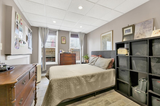 bedroom with recessed lighting, a drop ceiling, and wood finished floors