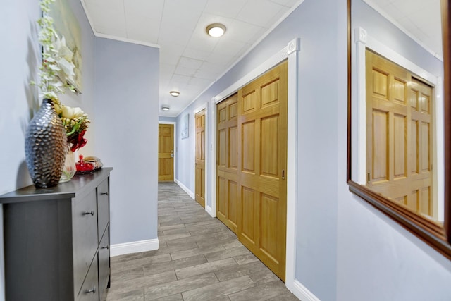 corridor featuring baseboards and wood tiled floor