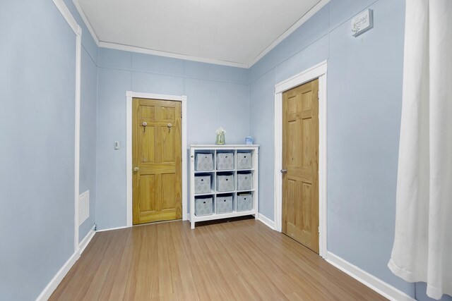 empty room with baseboards, wood finished floors, and ornamental molding