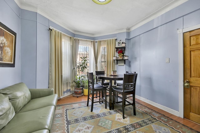 dining area with ornamental molding and wood finished floors