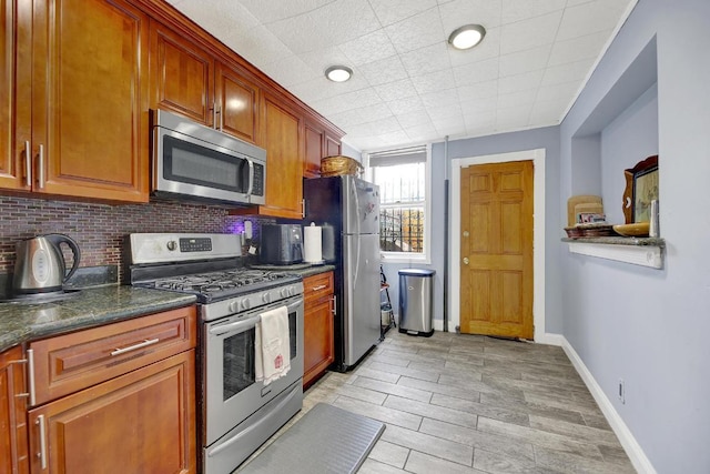 kitchen featuring backsplash, dark stone countertops, and stainless steel appliances