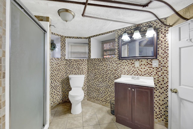 full bathroom featuring vanity, tile patterned floors, a stall shower, and tile walls