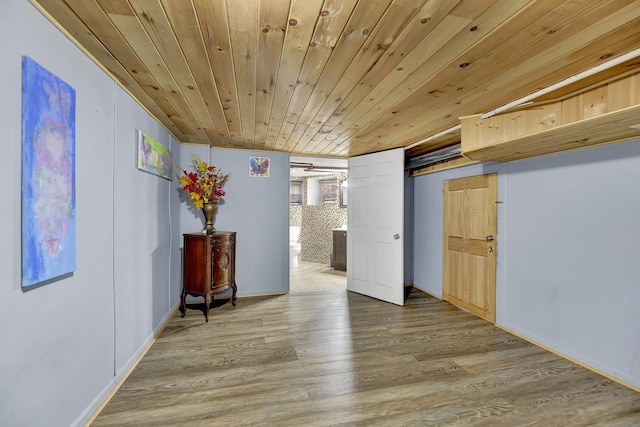 empty room with light wood-style floors and wooden ceiling