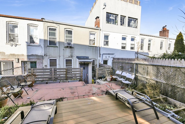 rear view of house with a patio, fence, and stucco siding