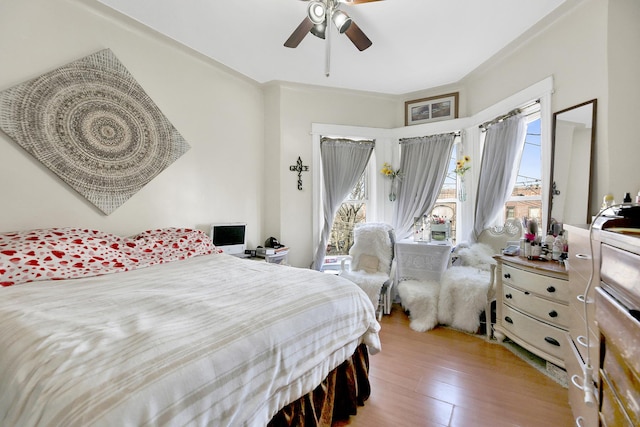bedroom featuring ceiling fan, access to outside, and wood finished floors