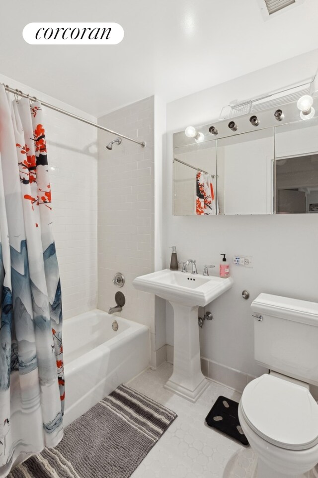 bathroom featuring toilet, tile patterned flooring, and shower / bath combo with shower curtain