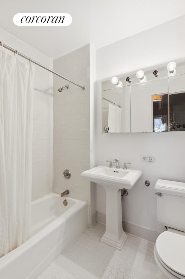 bathroom featuring tile patterned flooring, shower / bath combination with curtain, toilet, and baseboards