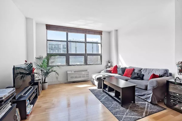 living room featuring heating unit and light hardwood / wood-style flooring