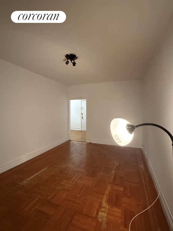 unfurnished room featuring dark parquet floors