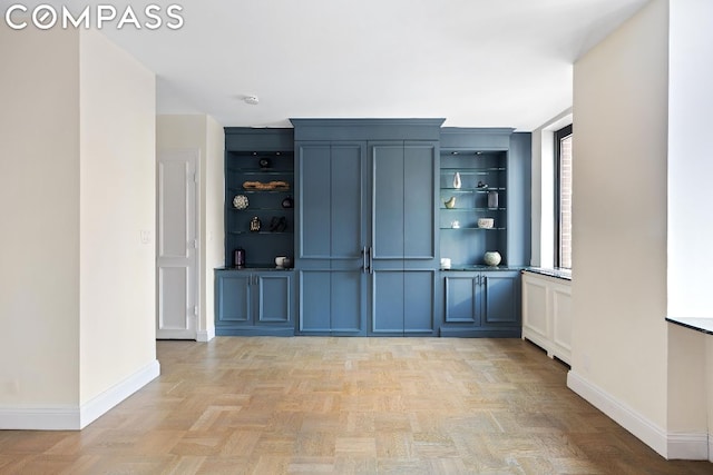 bar featuring light parquet flooring and blue cabinetry