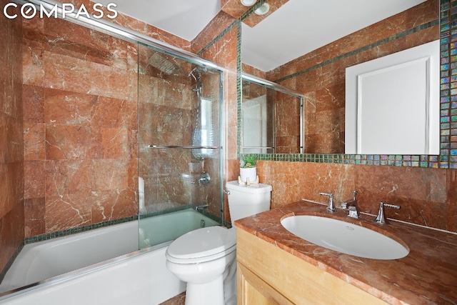 full bathroom featuring toilet, tasteful backsplash, shower / bath combination with glass door, tile walls, and vanity