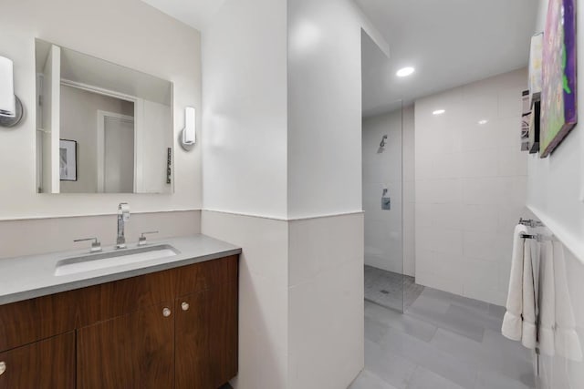 bathroom with vanity and a tile shower