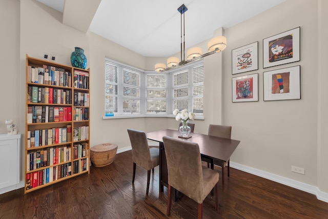 dining room with an inviting chandelier, baseboards, and wood finished floors