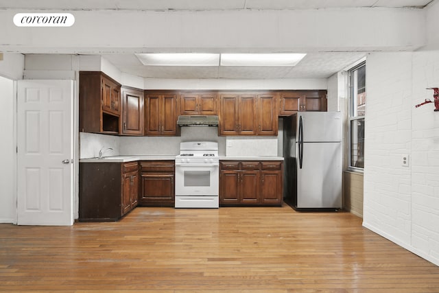 kitchen featuring gas range gas stove, light countertops, visible vents, freestanding refrigerator, and under cabinet range hood