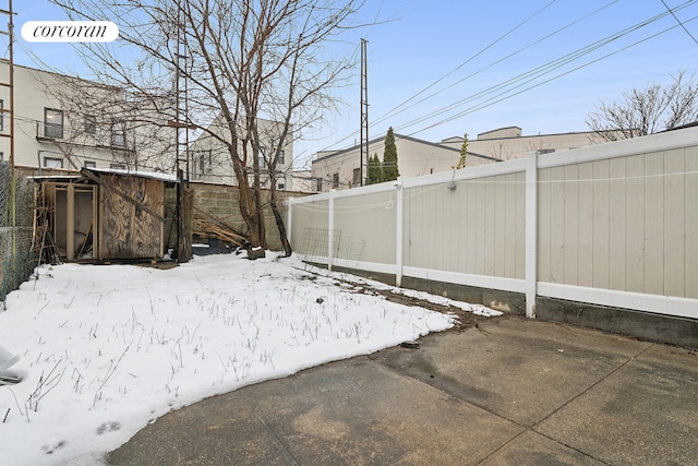 view of yard featuring fence, an outdoor structure, and a storage unit