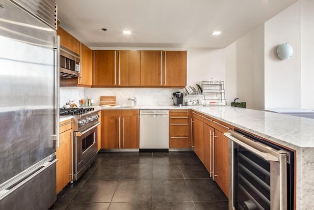 kitchen with premium appliances, beverage cooler, brown cabinets, and a peninsula