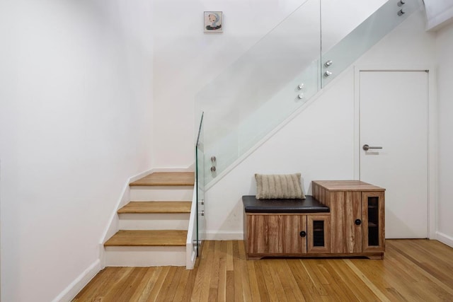 staircase with baseboards and wood finished floors