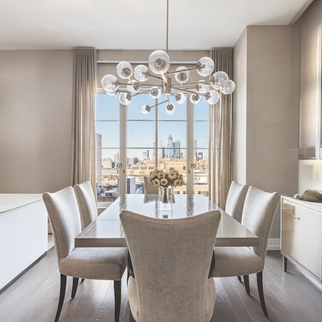 dining area featuring french doors, an inviting chandelier, wood finished floors, and a city view