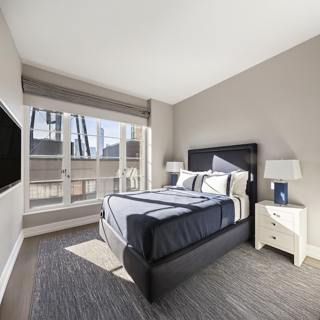 bedroom with baseboards and wood finished floors