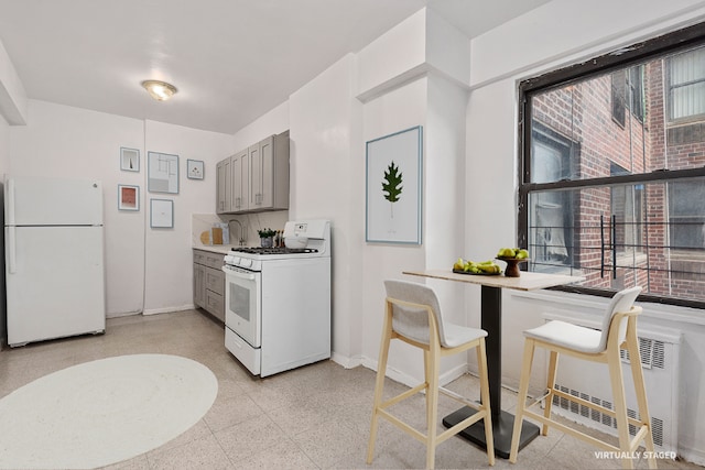 kitchen with plenty of natural light, white appliances, gray cabinets, and tasteful backsplash