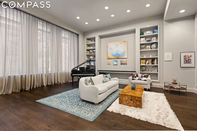 living area featuring built in features and dark hardwood / wood-style flooring