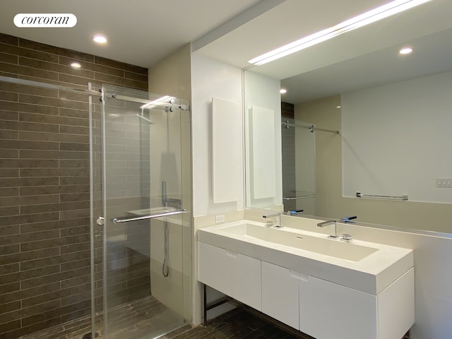 bathroom with double vanity, a stall shower, visible vents, a sink, and recessed lighting