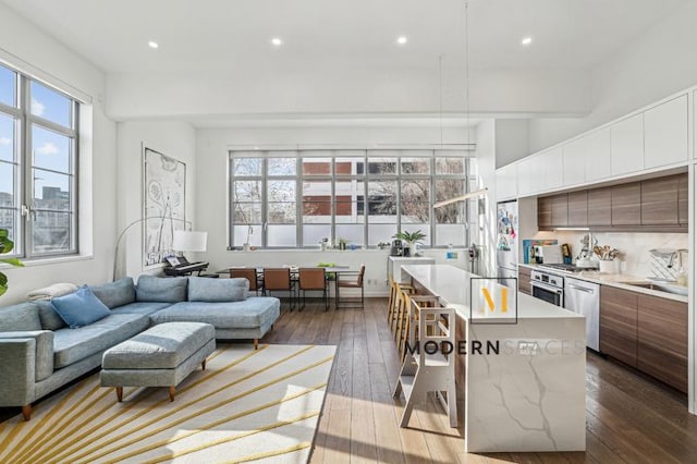 kitchen with stainless steel dishwasher, sink, hardwood / wood-style flooring, and a kitchen island