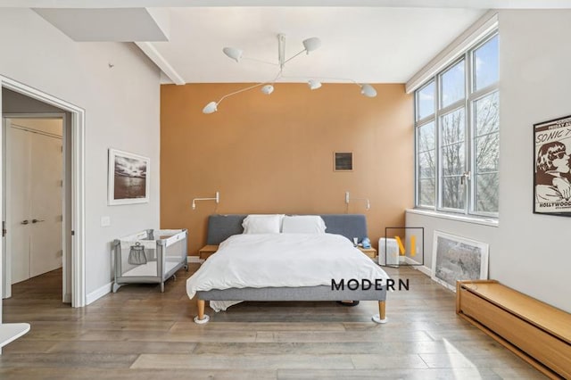 bedroom with a baseboard heating unit and hardwood / wood-style floors