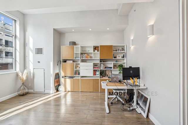 home office with light hardwood / wood-style floors